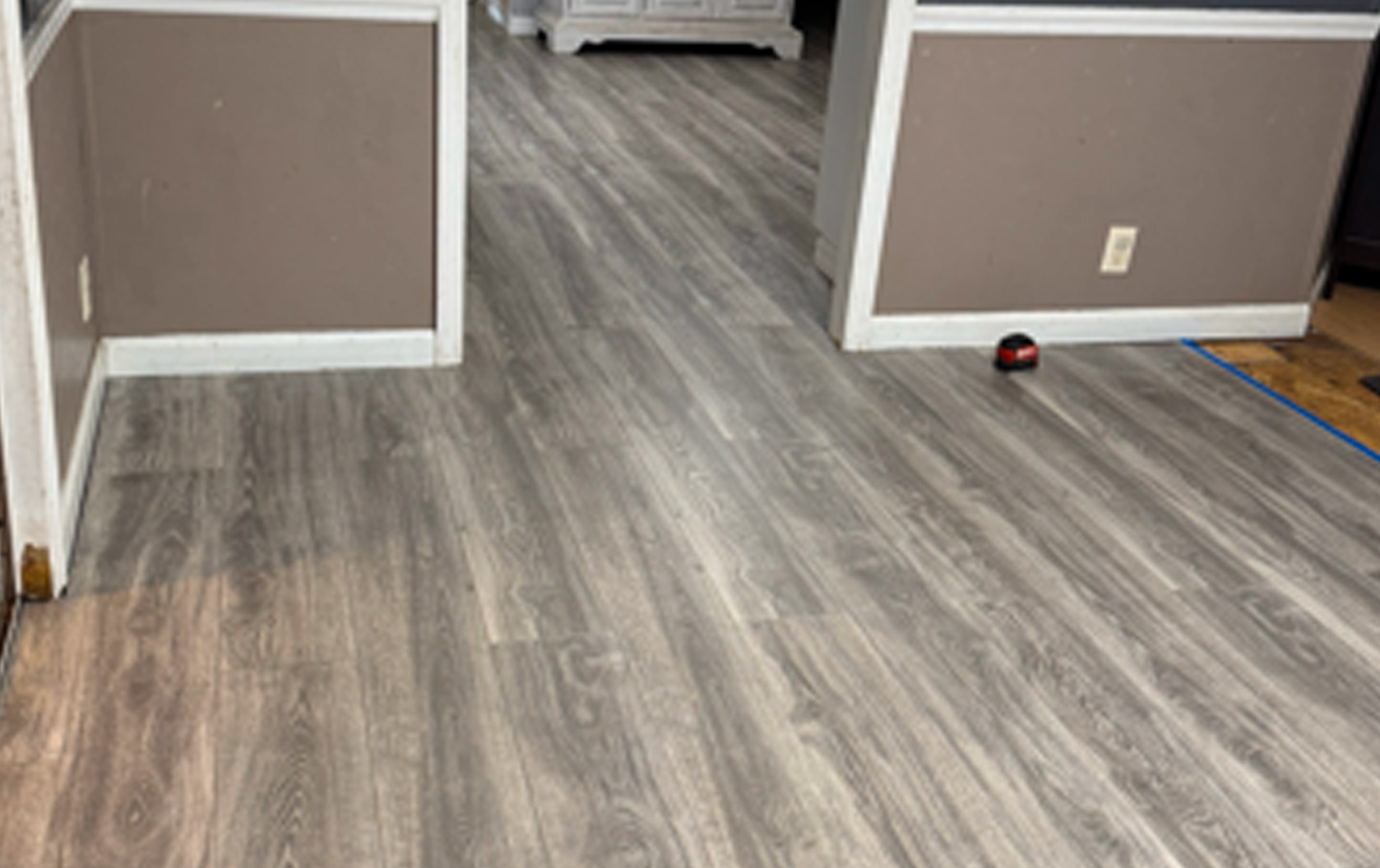 image shows new flooring with fresh baseboard and chair rail.